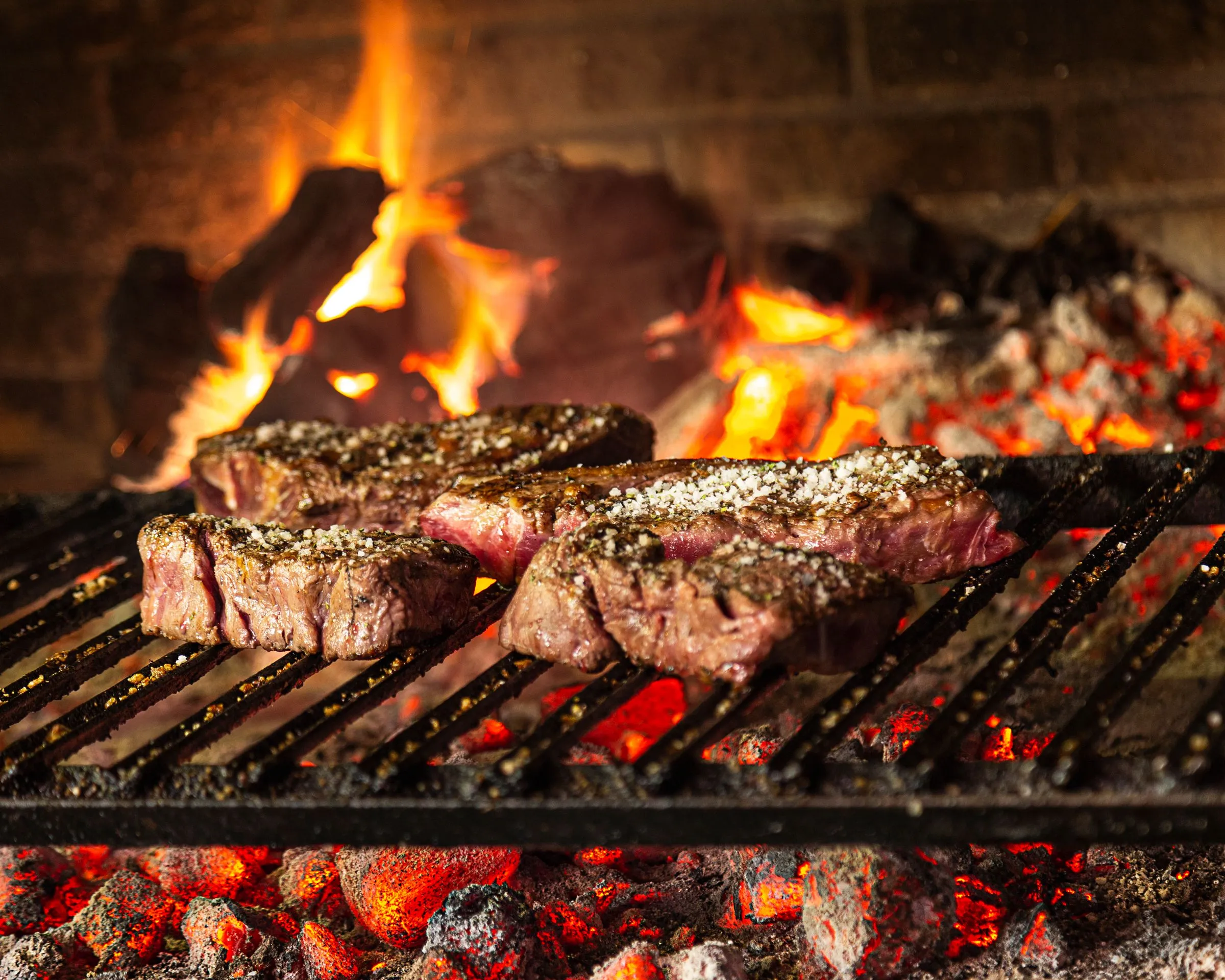 Txuletas de vaca vieja sobre la parrilla de leña de Asador Artebe, con las brasas al rojo